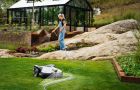 Privater Mähroboter im Garten mit Kameratechnik – intelligente, sichere Rasenpflege rund ums Wohnhaus.