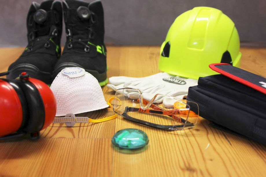 Arbeitsschutz-Ausrüstung mit Helm, Handschuhen, Schutzbrille und Sicherheitsschuhen – persönliche Schutzausrüstung für Handwerk und Industrie.