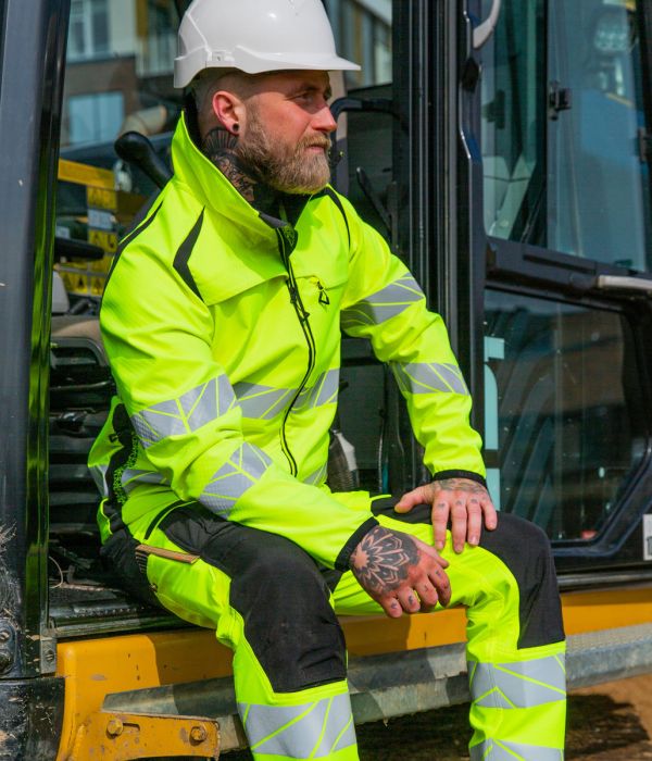 Mitarbeiter in Warnschutzkleidung auf einer Baustelle – gut sichtbare und sichere Arbeitskleidung für Bau und Industrie.