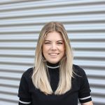 Porträt einer Mitarbeiterin von Werkzeug Schultze vor dem Firmengebäude – persönliche Ansprechpartnerin für das Marketing.