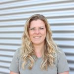 Porträt einer Mitarbeiterin von Werkzeug Schultze vor dem Firmengebäude – persönliche Ansprechpartnerin der Buchhaltung.