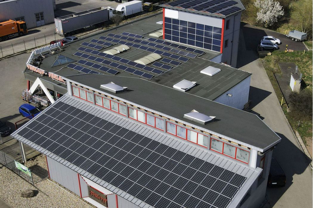 Luftaufnahme des Firmengebäudes von Werkzeug Schultze mit Photovoltaikanlage auf dem Dach zur nachhaltigen Energiegewinnung.