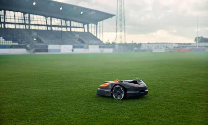 Gewerblicher Mähroboter im Einsatz auf einem Fußballplatz – effiziente Rasenpflege für Sportanlagen und große Grünflächen.