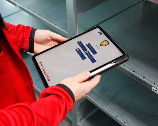 Digitale Regalprüfung mit Tablet am Metallregal – Erfassung von Prüfdaten für sichere und normgerechte Lagertechnik.